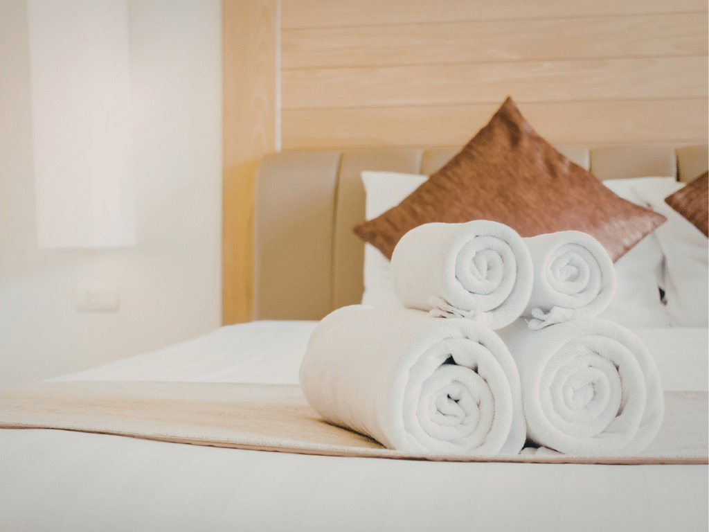 Serviettes propres préparées sur un lit pour une location courte durée en Vendée illustrant l’expérience voyageurs